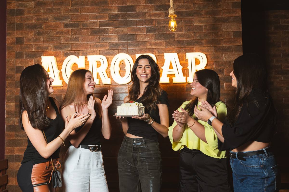 Grupo de amigas em frente ao letreiro Agrobar