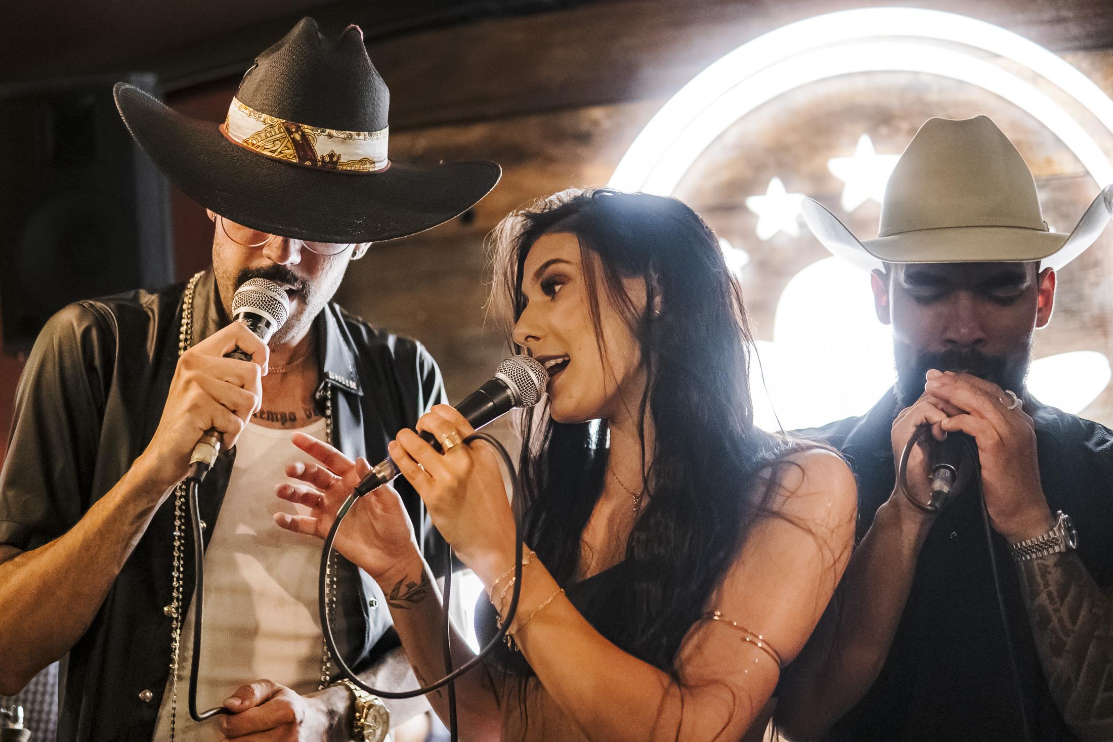 Artistas sertanejos cantando no palco do Agrobar